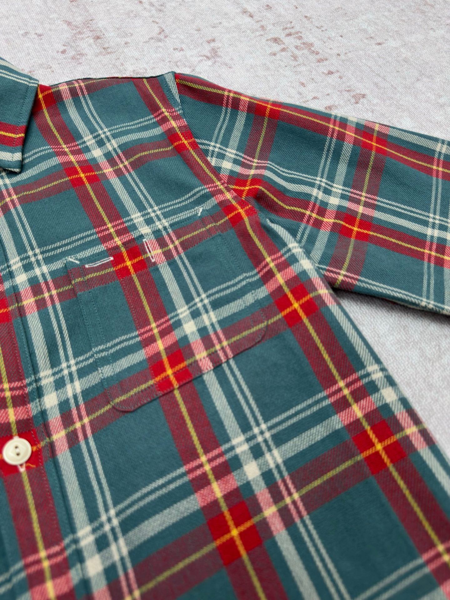 Teal plaid shirt with spread collar, red and yellow lines, and button closure