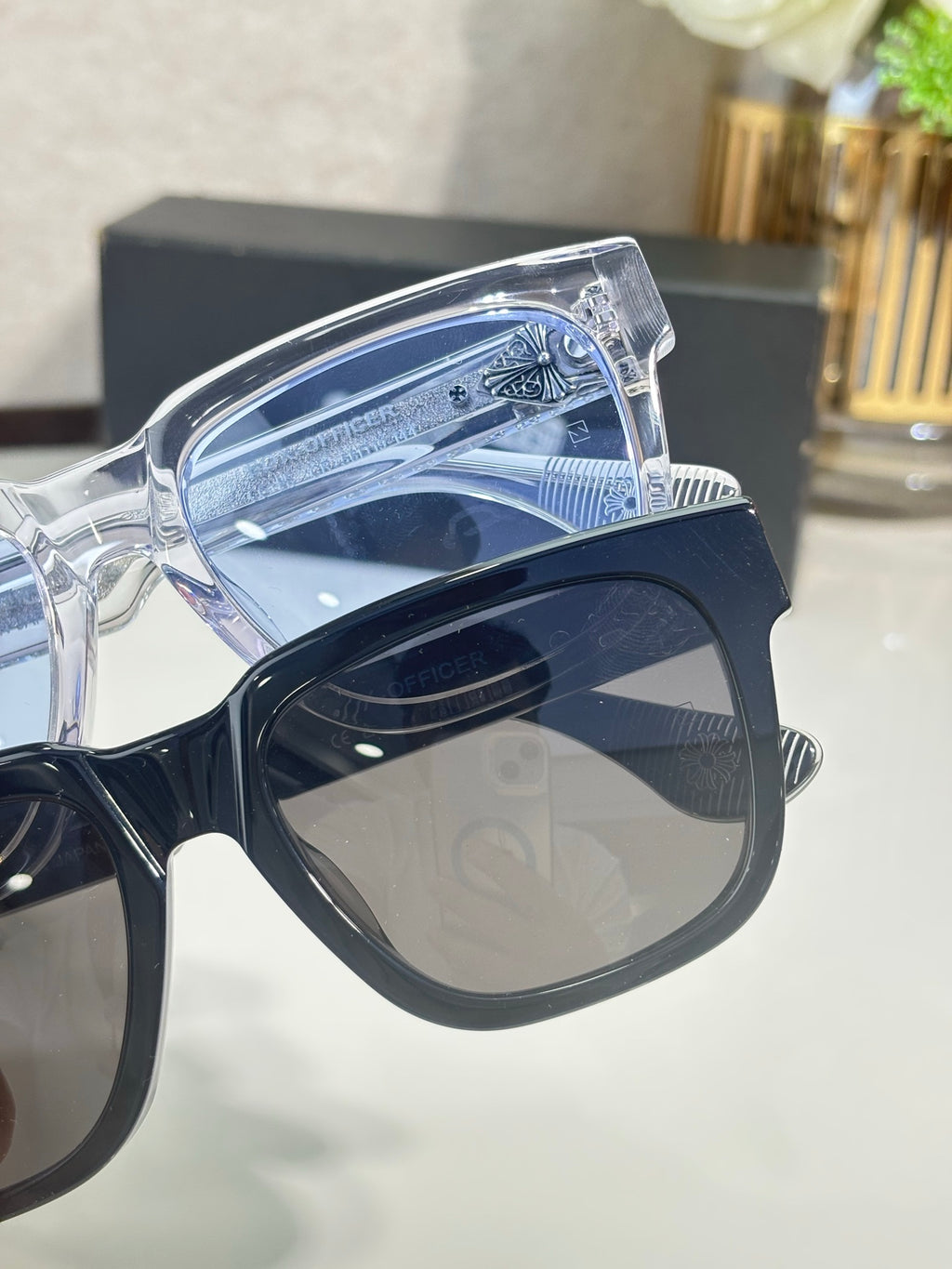 Clear sunglasses frame close-up with blue-tinted lens and chrome detailing