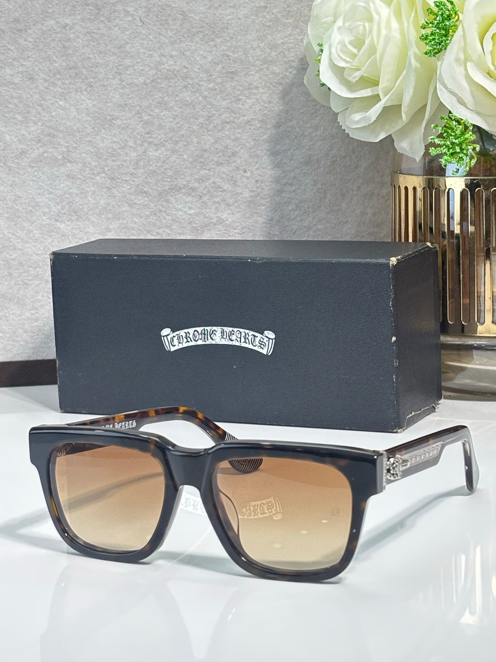 Black rectangular sunglasses with brown-tinted lenses and chrome metal temples