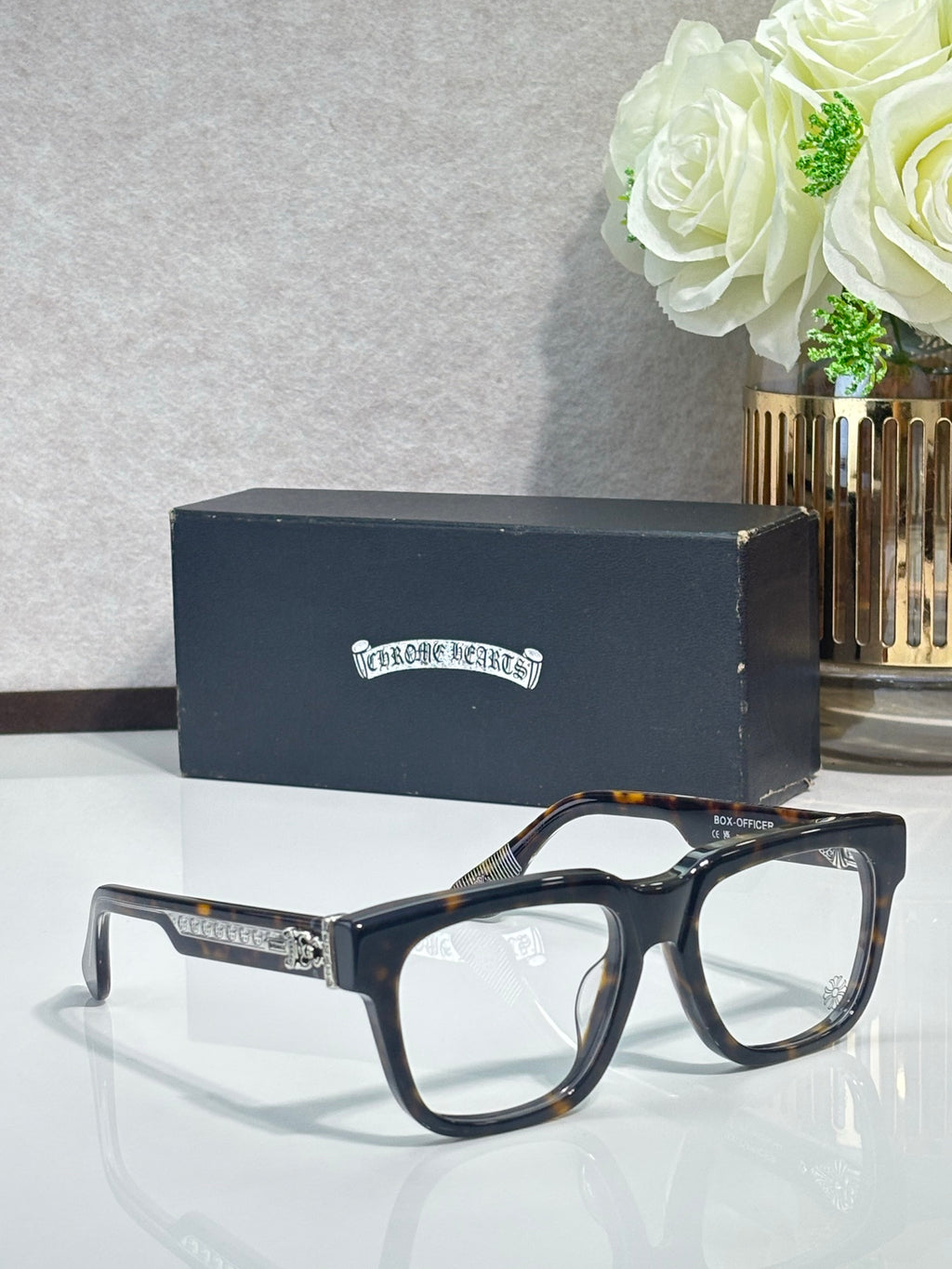 Chrome glasses with dark tortoiseshell rectangular frames and gold detailing