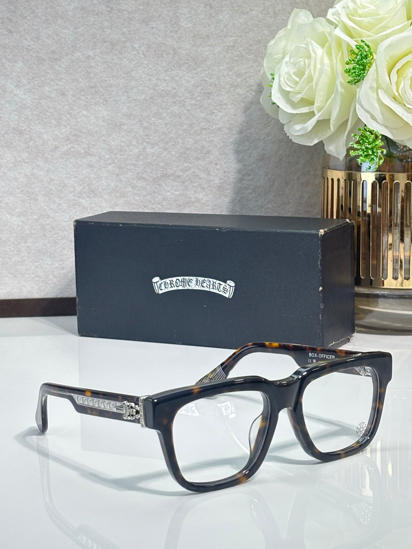 Chrome glasses with dark tortoiseshell rectangular frames and gold detailing