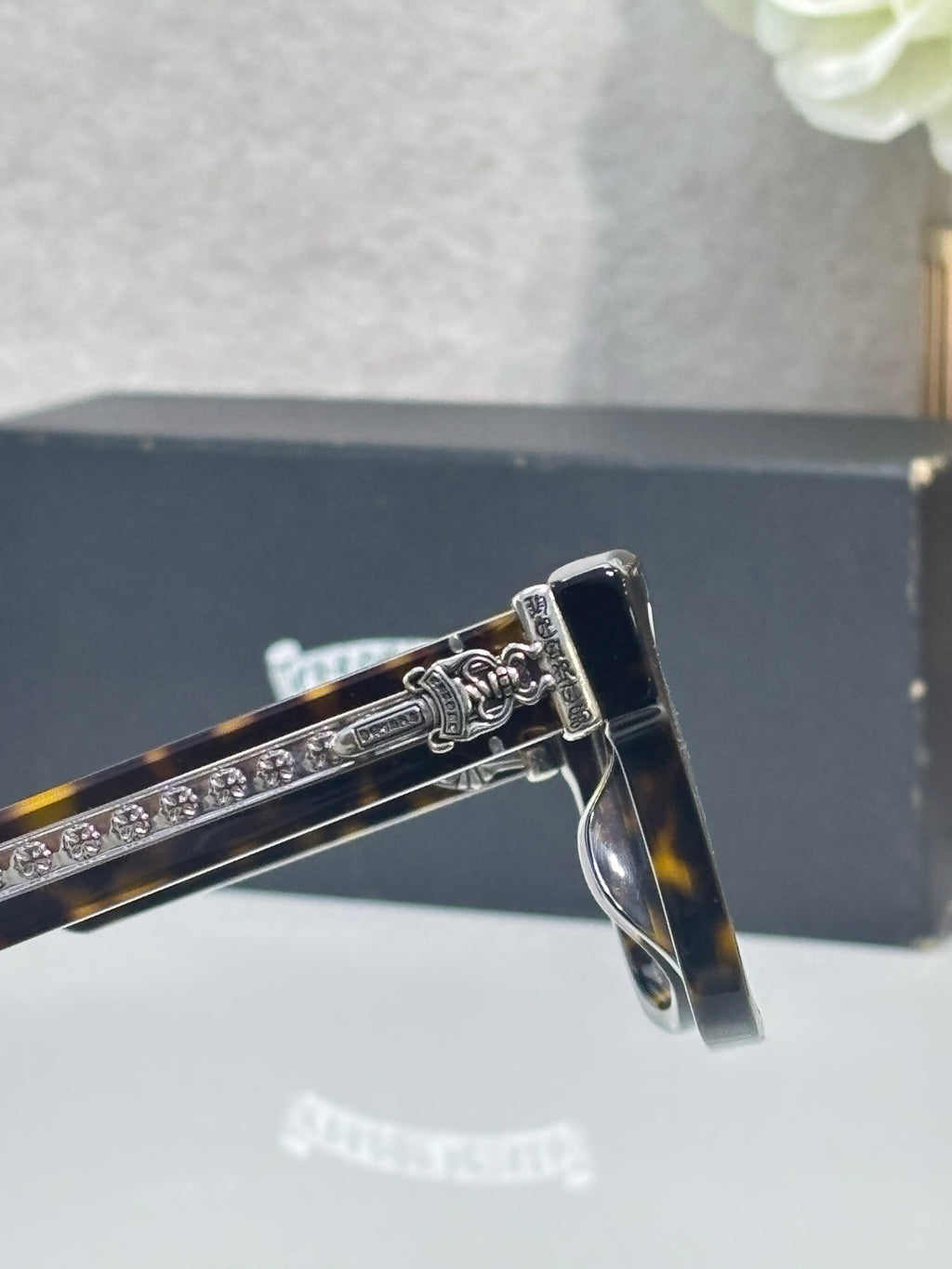 Chrome glasses metal hinge detail on rectangular frame