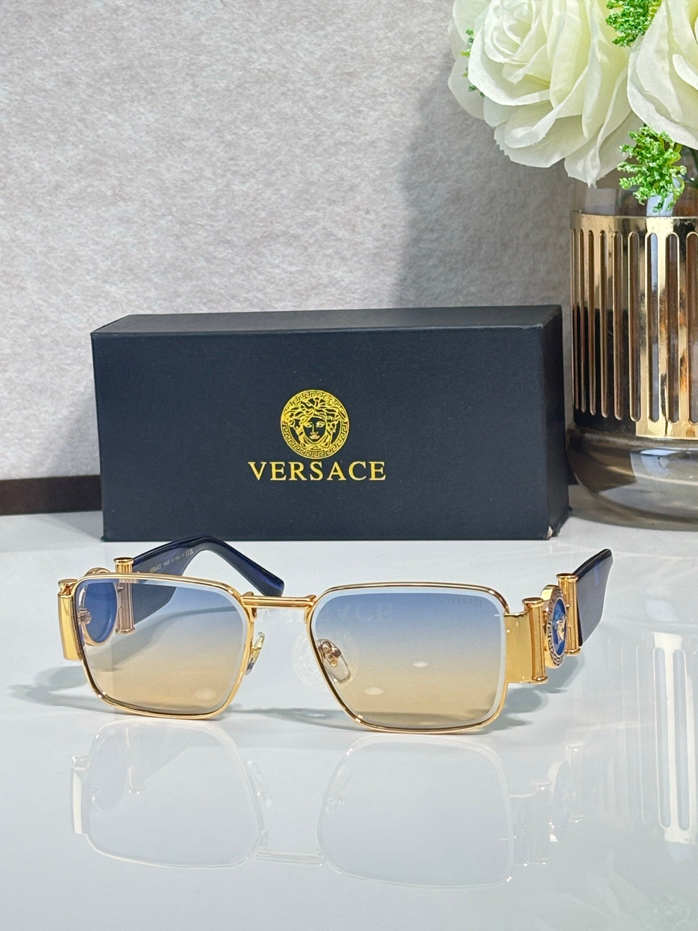 Gold-tone square eyeglasses with blue-to-amber gradient lenses and metal temples