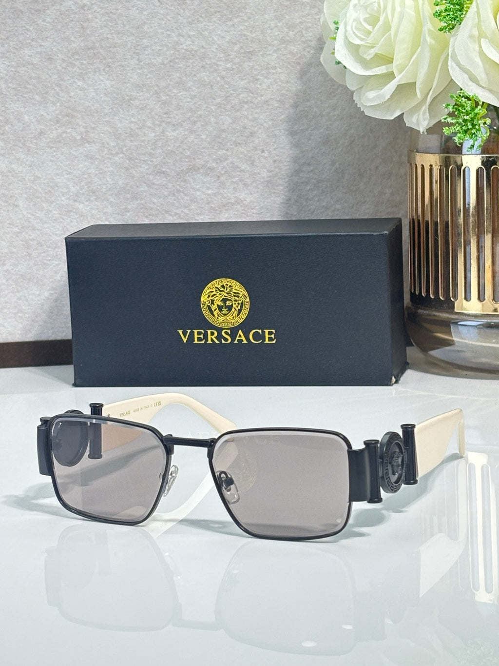 Black square eyeglasses with dark lenses, gold hinges, and sturdy temple arms