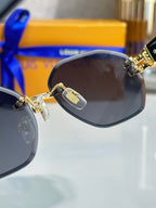 Close-up round sunglasses with dark lens and gold-tone temple emblem
