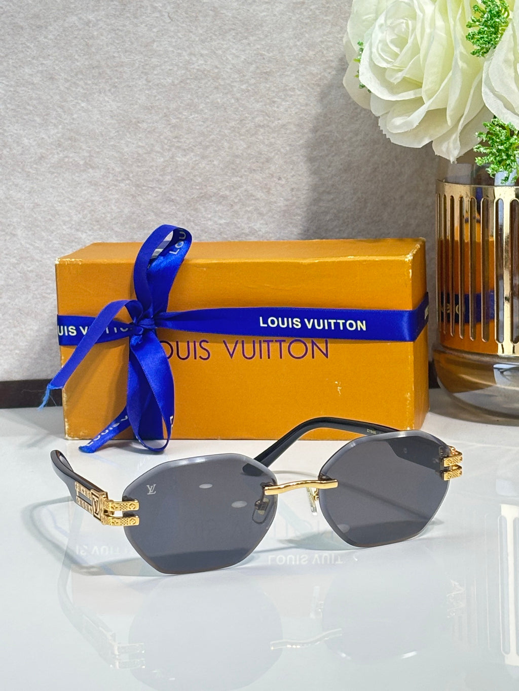 Round sunglasses with dark lenses and black-and-gold temple hardware