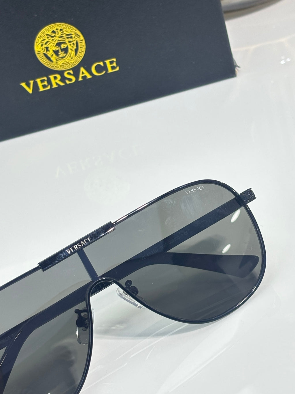 Sunglasses close-up with dark blue frames and smoky gray lenses, metal hinge detail