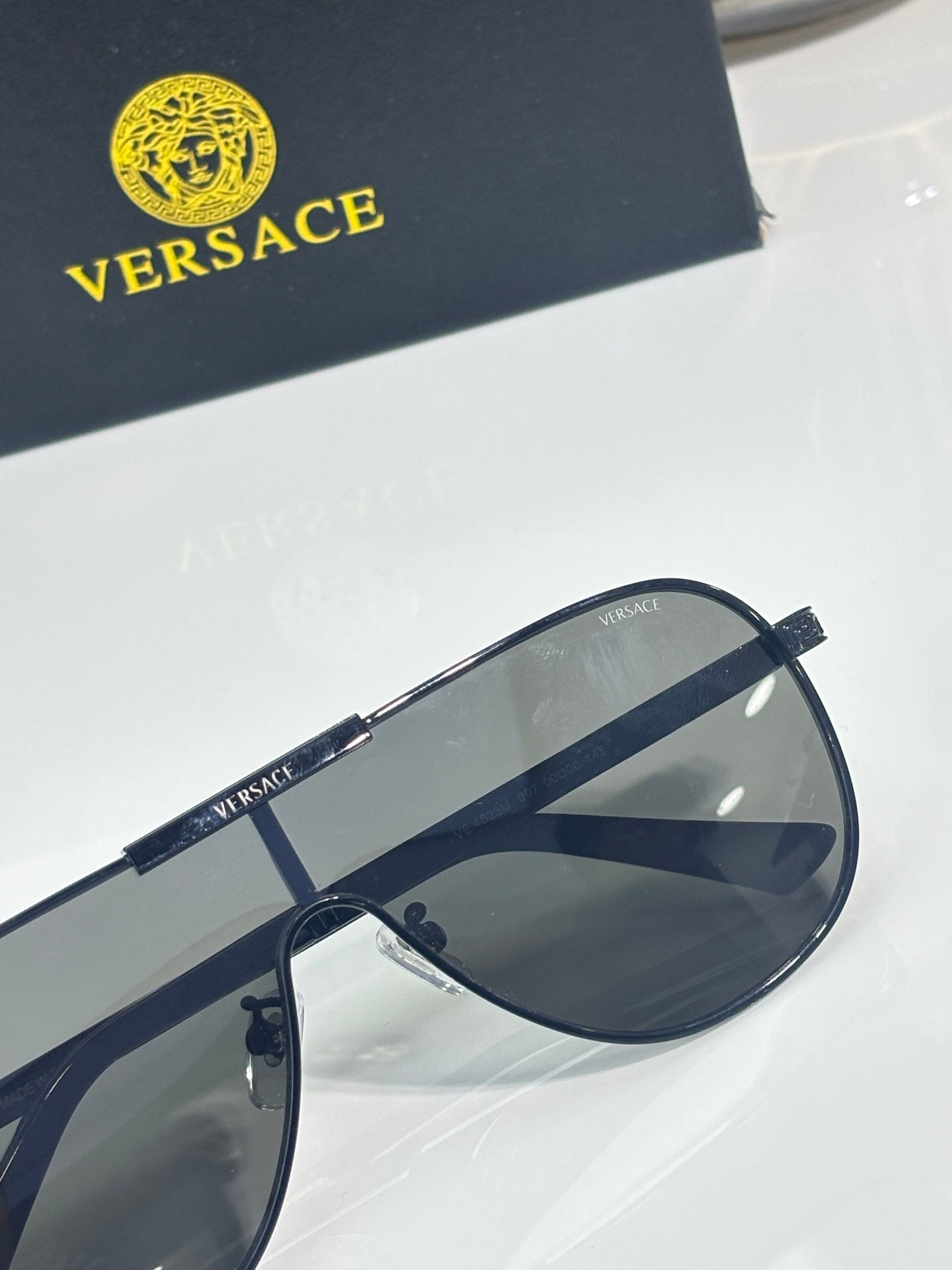 Sunglasses close-up with dark blue frames and smoky gray lenses, metal hinge detail