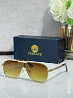 Sunglasses with gold-tone frames and amber gradient lenses, slim temple with logo pattern