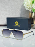 Sunglasses with dark blue frames and gradient gray-blue lenses, gold logo detail on temple