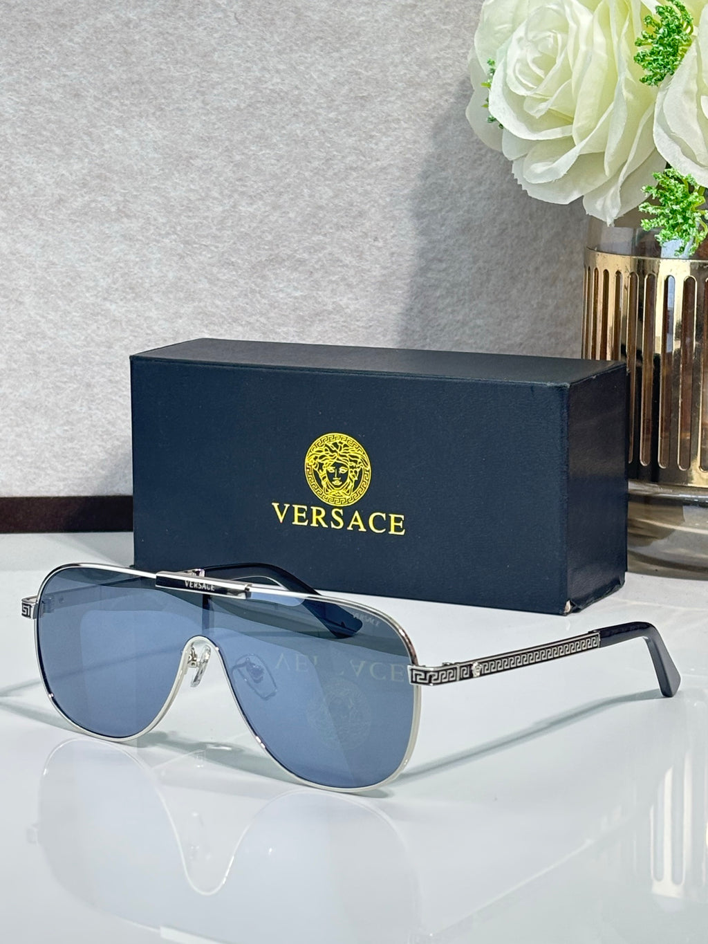 Sunglasses with dark blue frames and gradient blue lenses, ornate metal temple detail