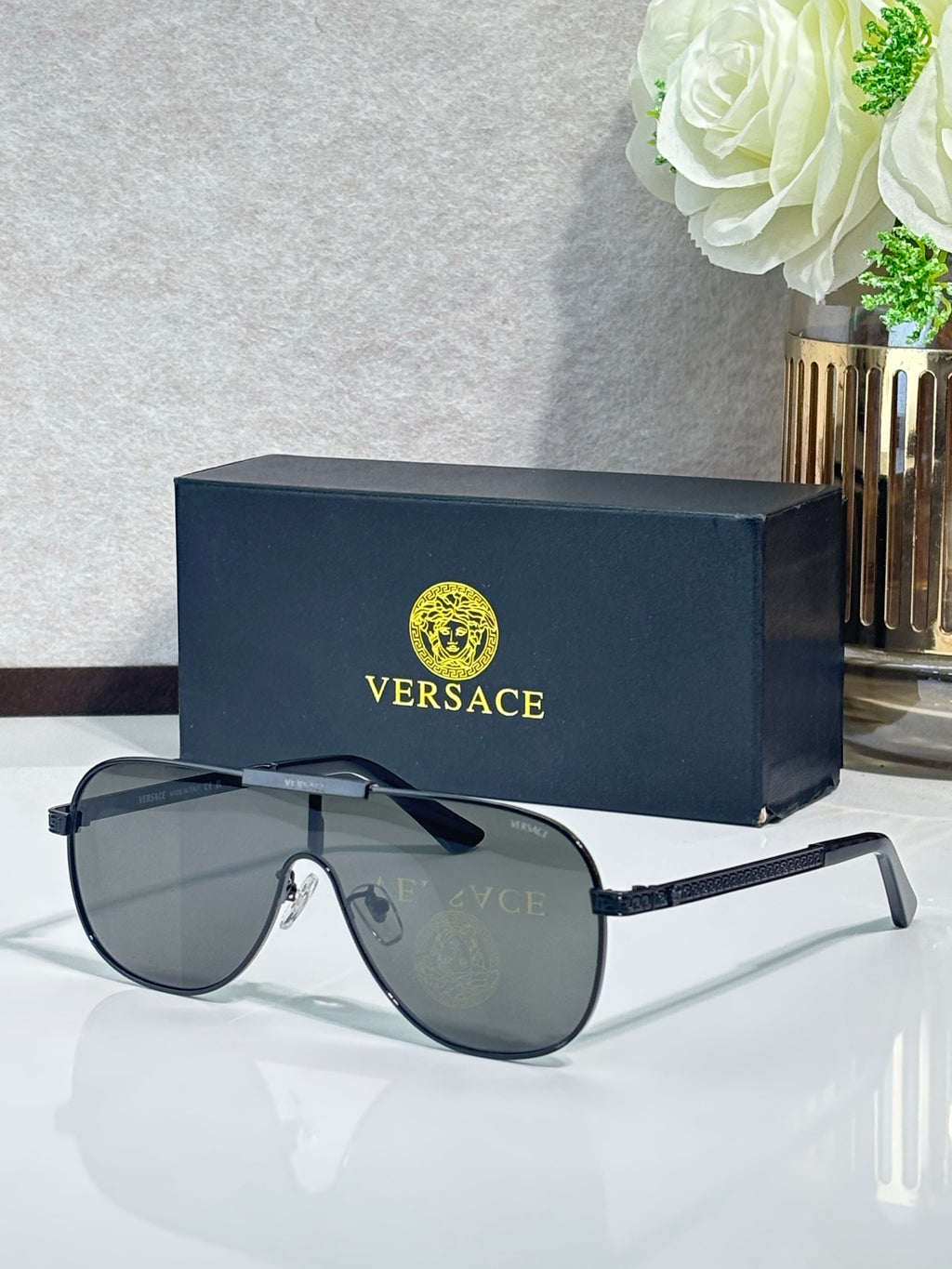 Sunglasses with dark frames and gradient gray lenses, metal temple detail near the hinge