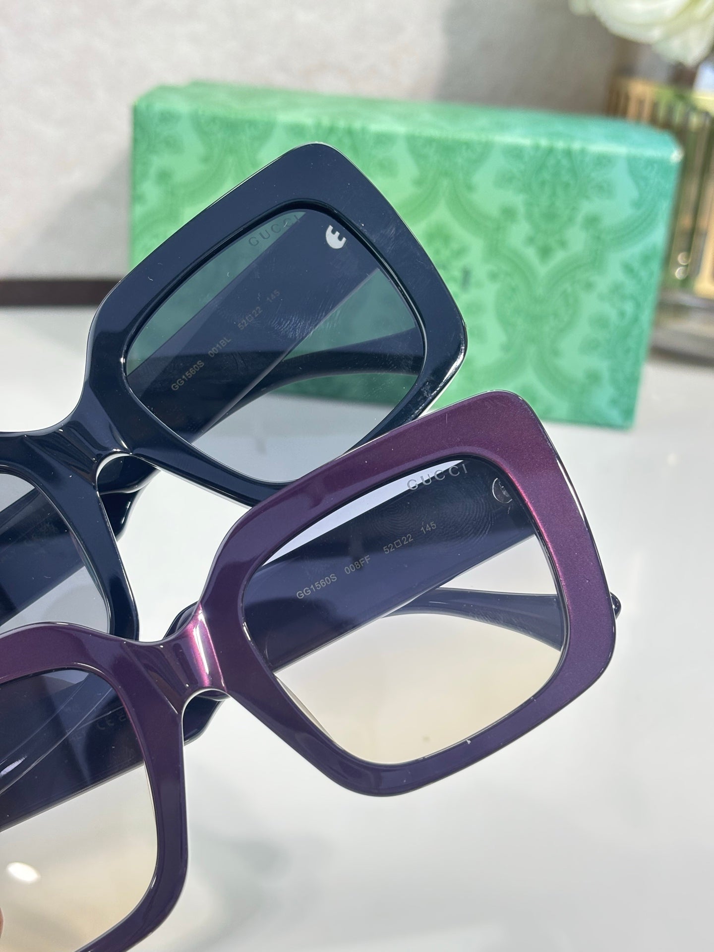 Two rectangular eyeglass frames: purple and dark navy, with tinted lenses