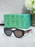 Gucci sunglasses with dark frame, tortoiseshell-pattern arms, gold GG logo