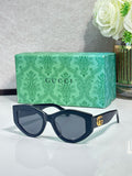 Gucci sunglasses with dark navy frame and tinted lenses, gold GG logo on temple