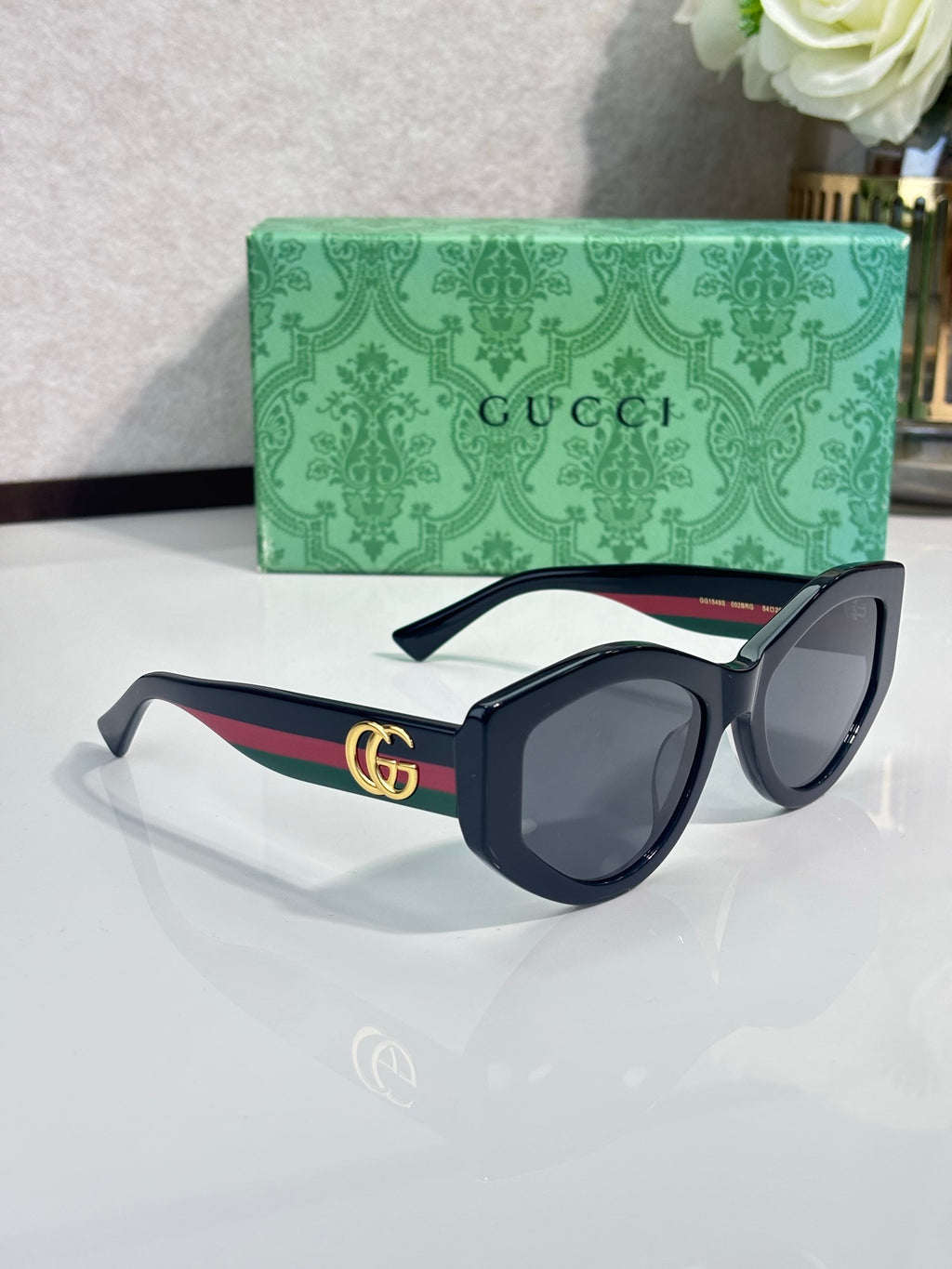 Gucci sunglasses with dark navy round frames and gold GG logo on temple