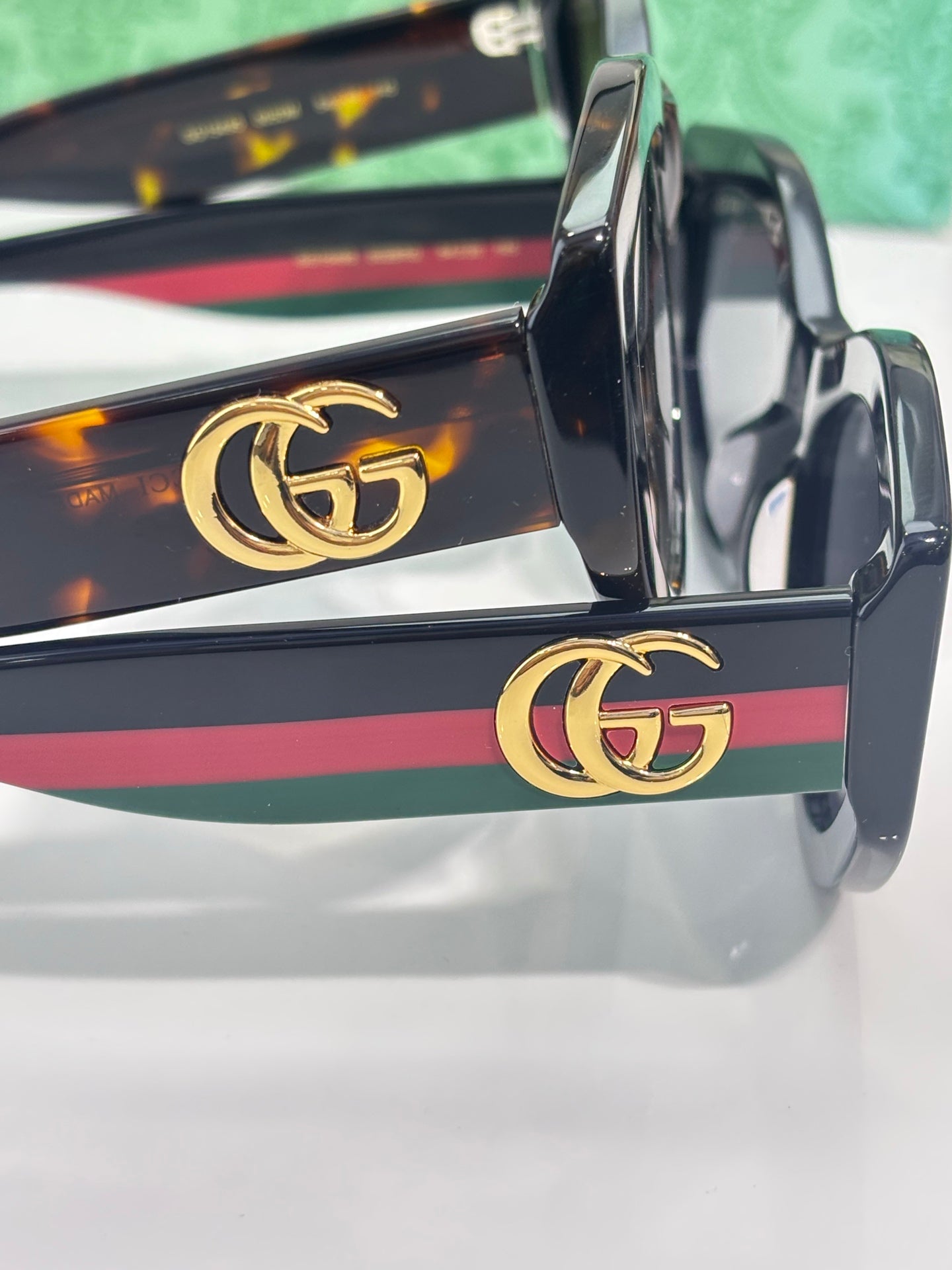 Gucci sunglasses temple close-up with gold GG logo and multicolor stripe