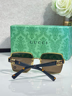 Gucci sunglasses with navy frames, gold hardware, and brown-tinted square lenses