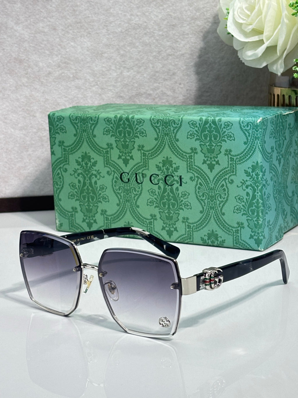 Gucci sunglasses with gold metal square frames and dark blue-tinted lenses