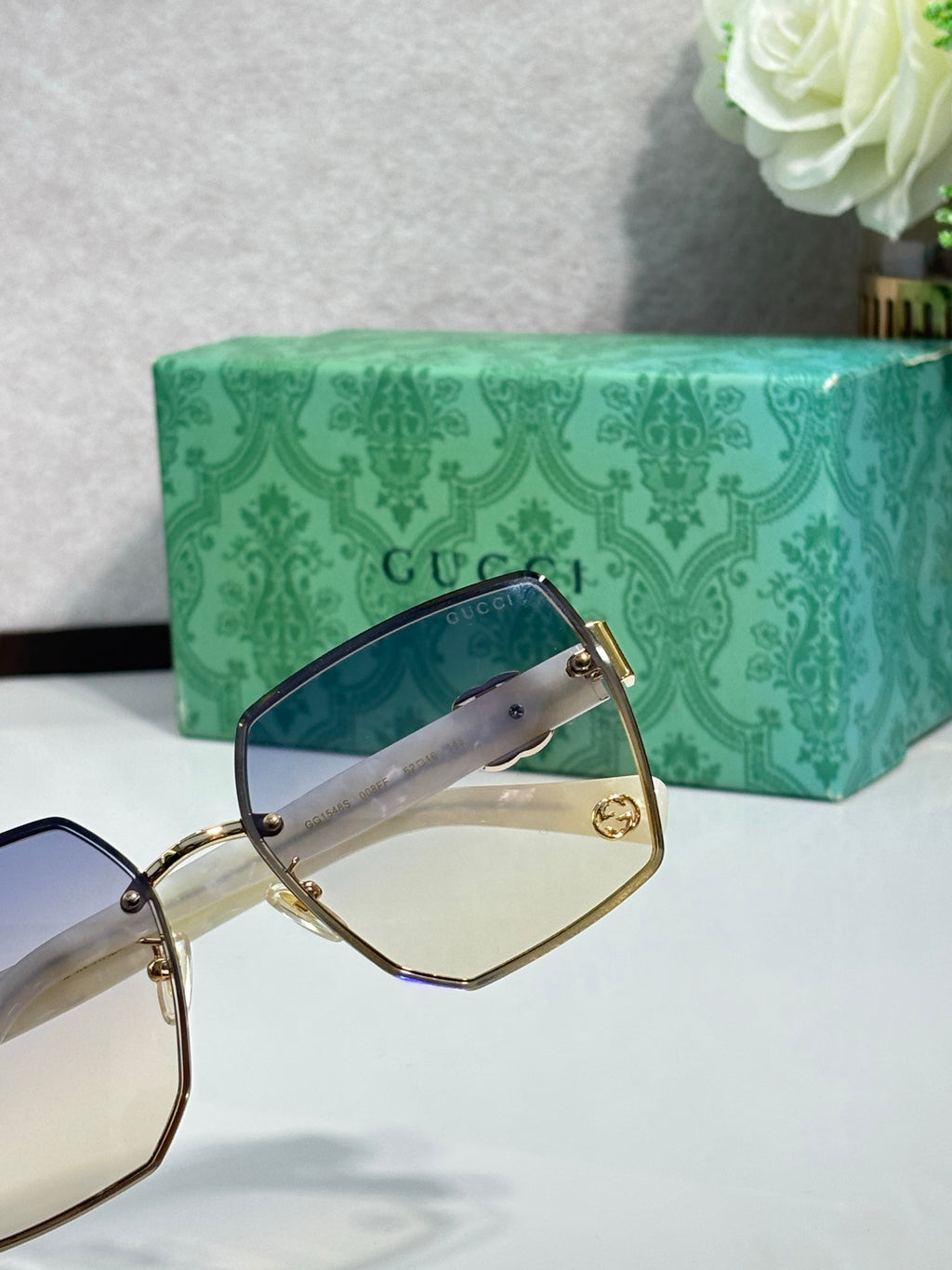 Gucci sunglasses close-up: gold frame with dark tinted lens and black temple