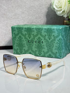 Gucci sunglasses with gold metal frame and light blue-tinted lenses