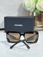 Chanel sunglasses with dark tortoiseshell cat-eye frames and gold CC emblems