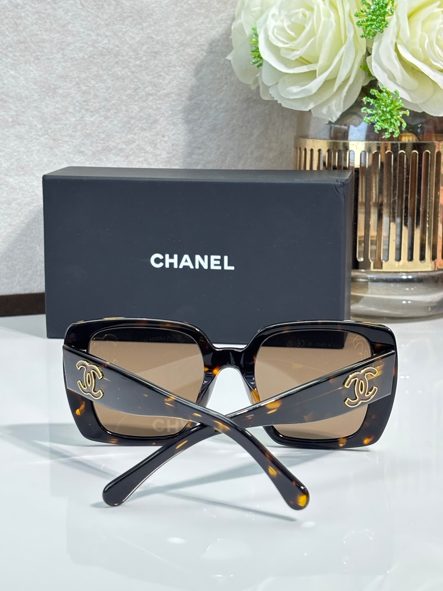 Chanel sunglasses with dark tortoiseshell cat-eye frames and gold CC emblems
