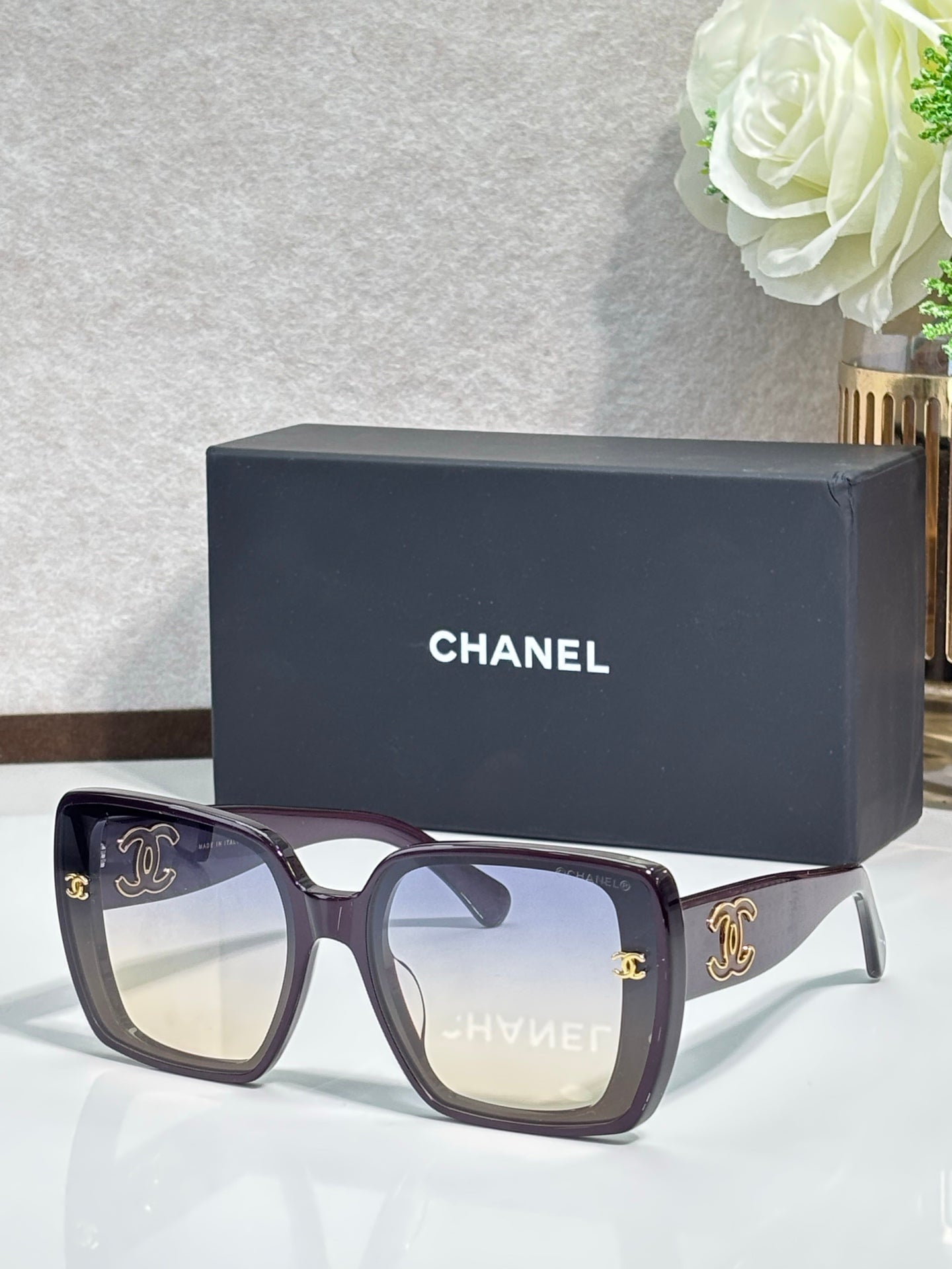 Chanel sunglasses with dark burgundy wide frames and gold CC logos