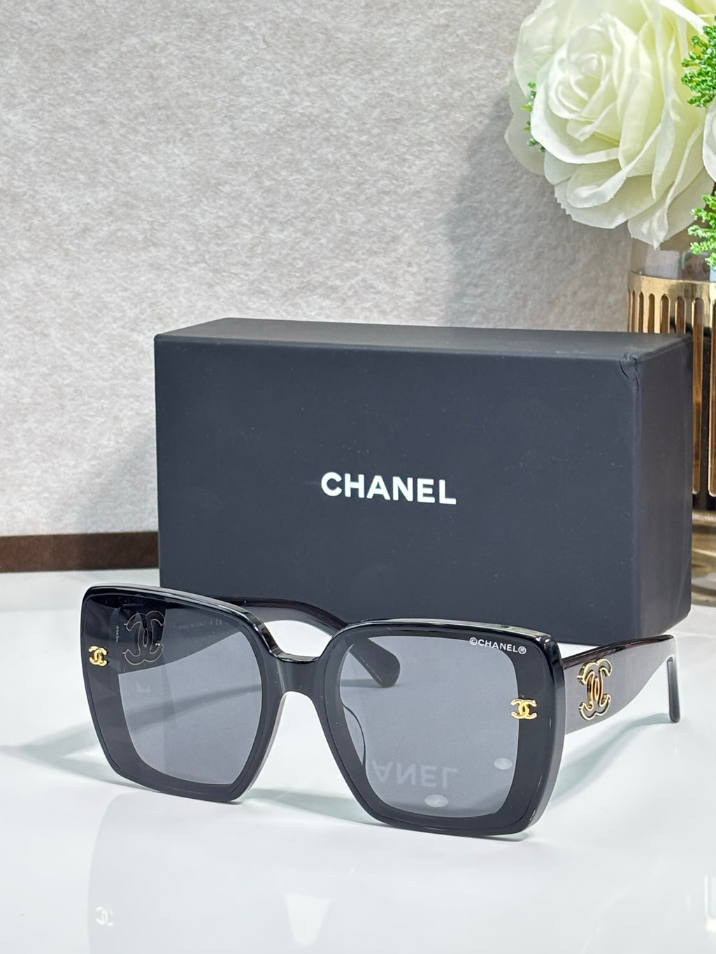 Chanel sunglasses with dark gray square frames and gold CC accents