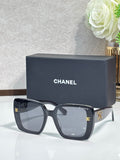 Chanel sunglasses with dark gray square frames and gold CC accents