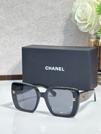 Chanel sunglasses with dark gray square frames and gold CC accents