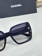 Chanel sunglasses close-up: dark frame with gold CC side emblem
