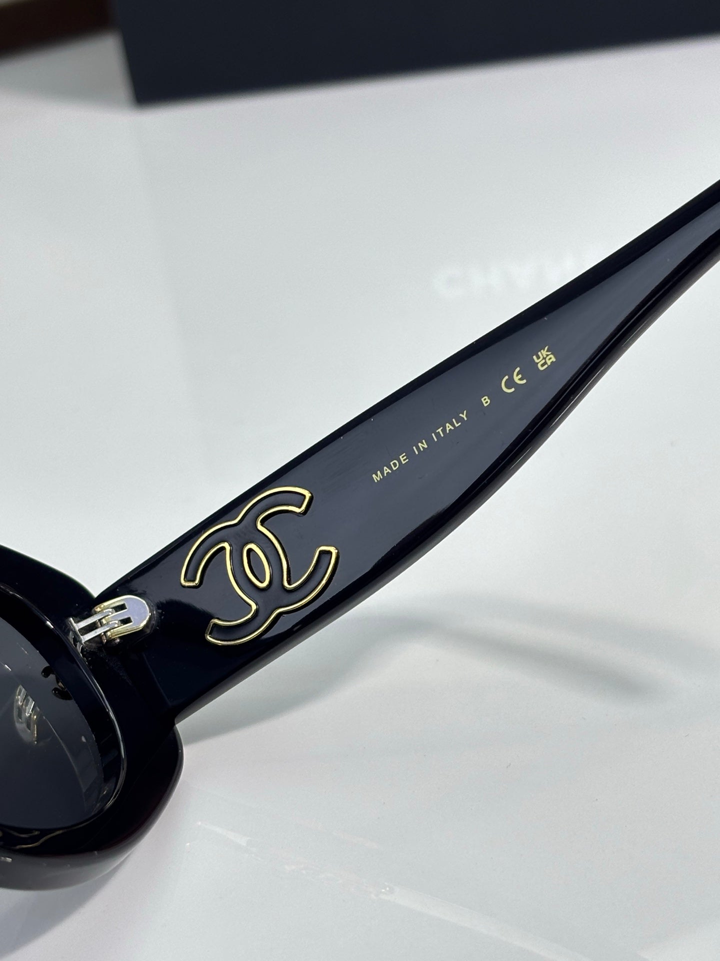 Chanel cat-eye sunglasses with gold script on dark blue temple and metal hinge