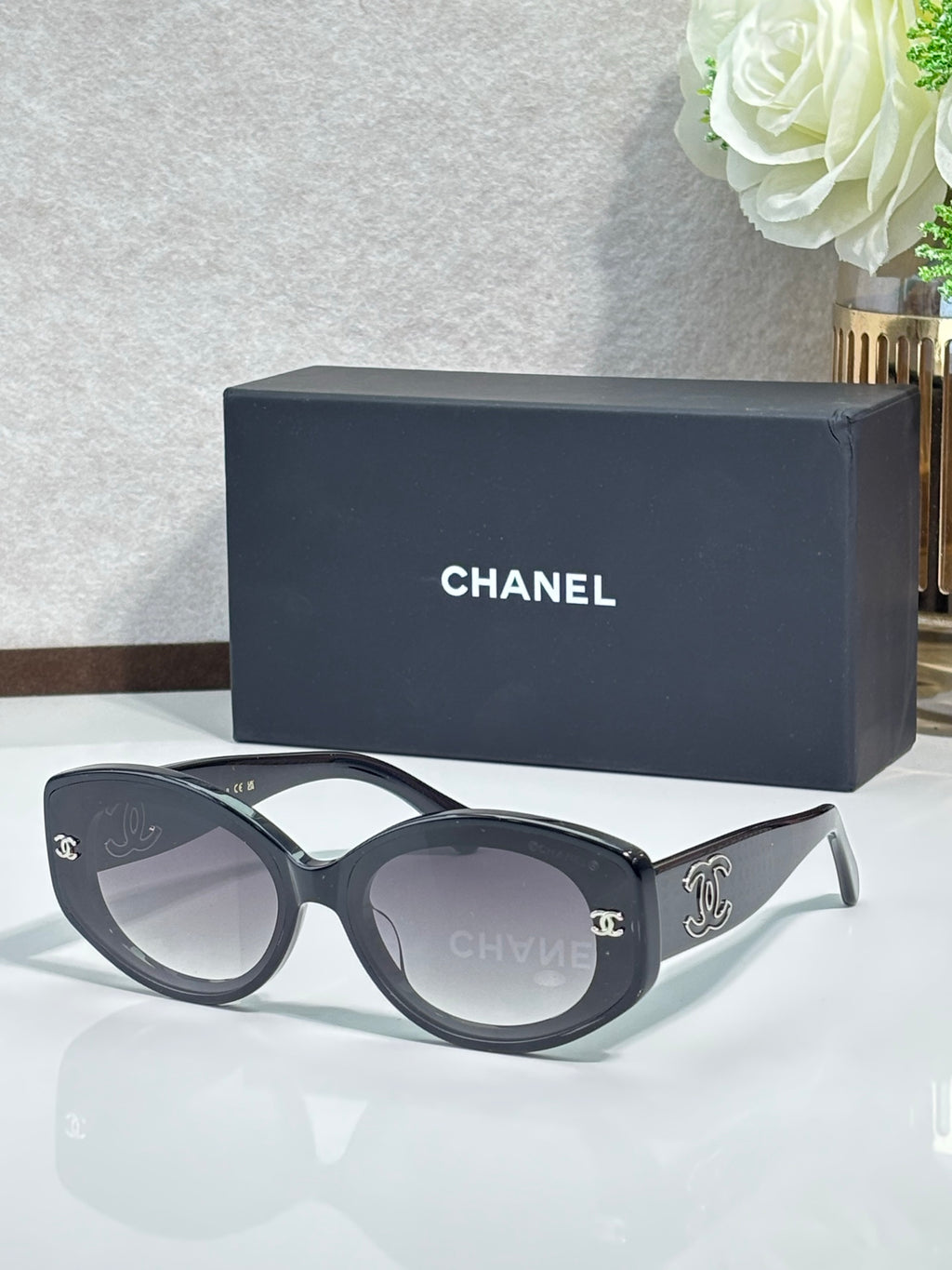 Chanel cat-eye sunglasses with dark frames and gold Chanel emblem on temples