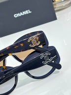 Chanel cat-eye sunglasses with dark blue side arms and gold logo details