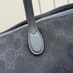 Gucci tote bag handle attachment close-up with dark gray stitched leather trim