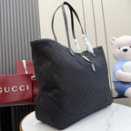 Gucci tote bag with dark textured exterior, angled view, and front pocket panel