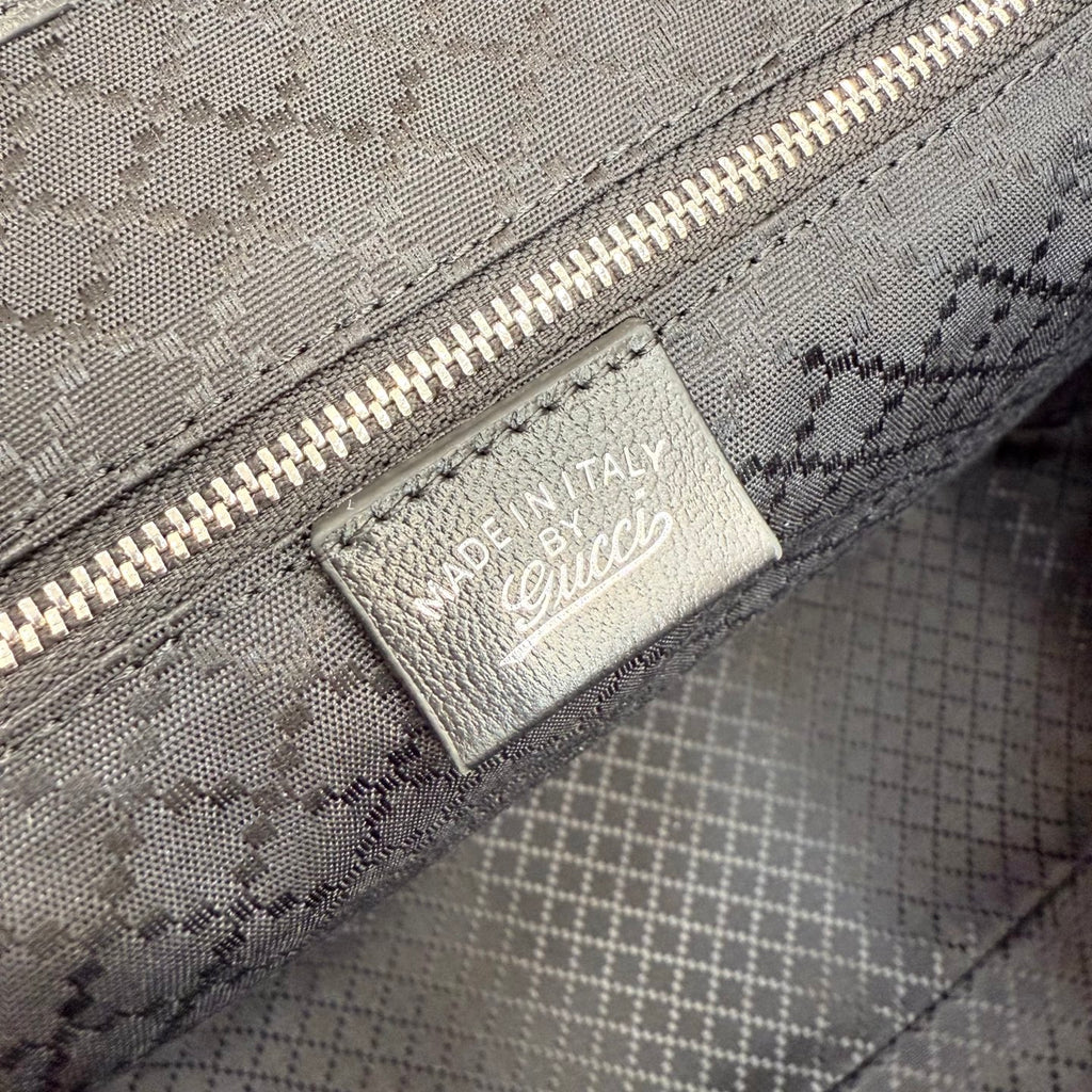 Gucci tote bag interior label patch on patterned lining near zipper
