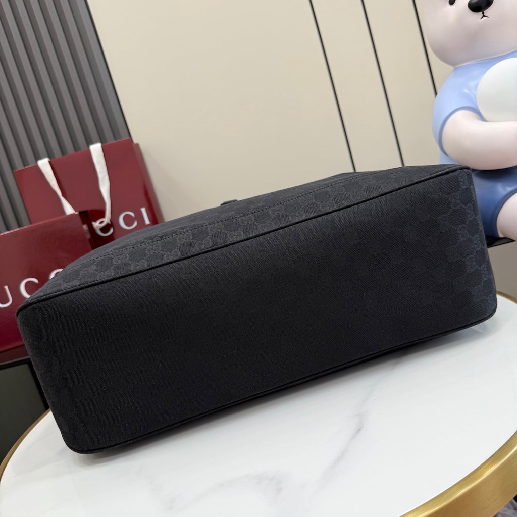 Gucci tote bag bottom view with dark gray exterior and flat, rounded base