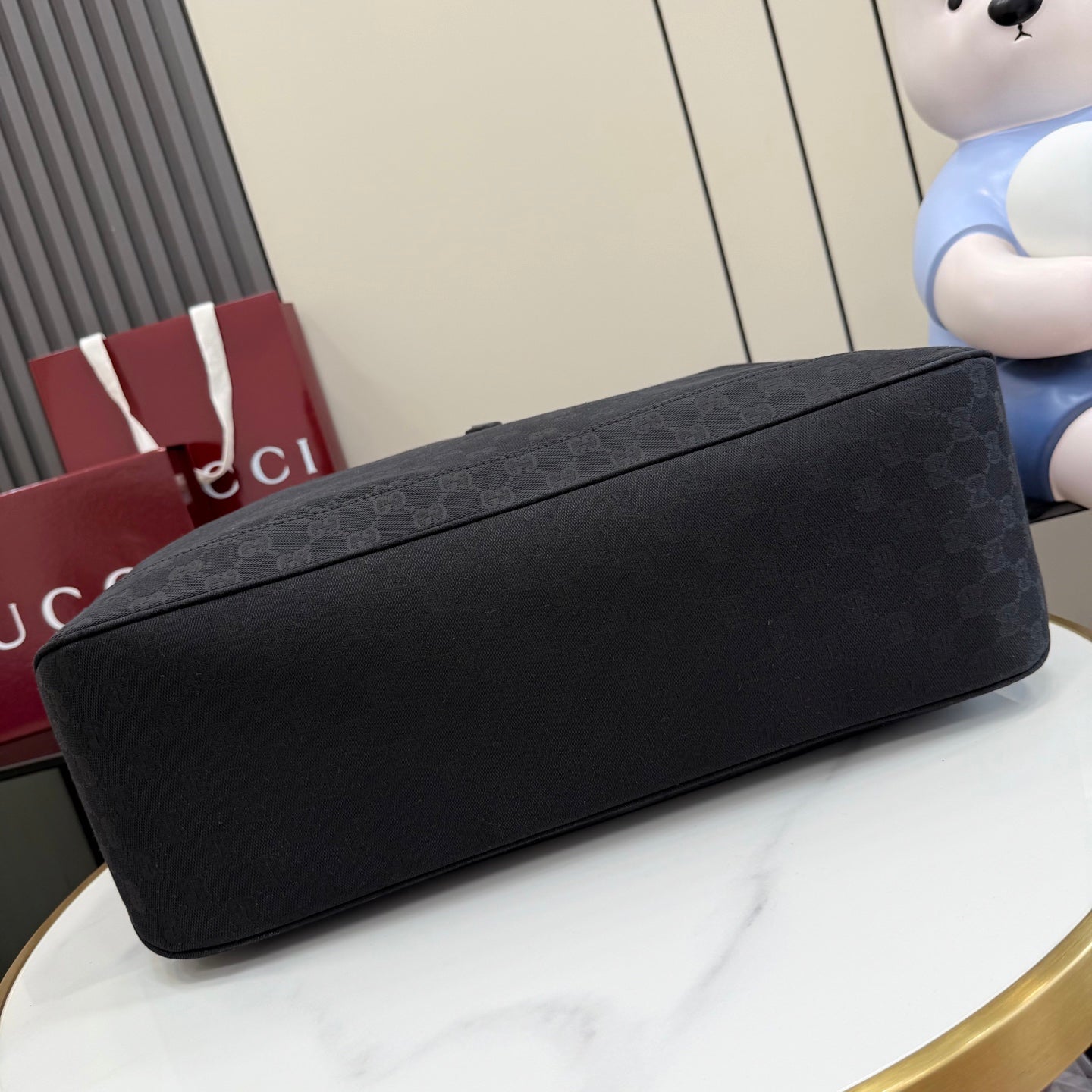 Gucci tote bag bottom view with dark gray exterior and flat, rounded base