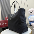 Gucci tote bag side view showing dark textured pattern and curved shoulder straps