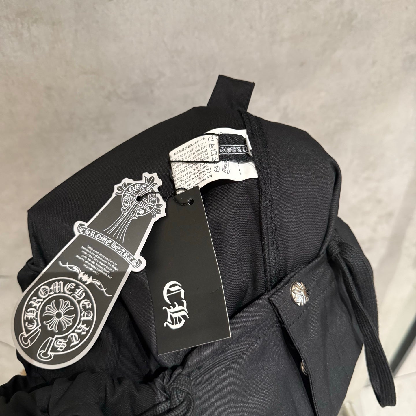 Black pants on hanger with fabric label and drawstring tie