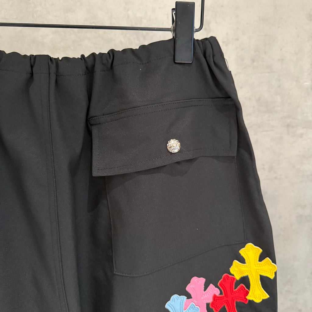 Black pants with side flap pocket and multicolor cross patch near hem
