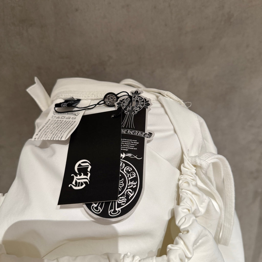 White drawstring pants with attached clothing tag and label