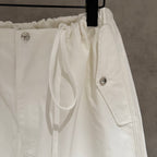 White drawstring waist pants with side pockets and metal button accents