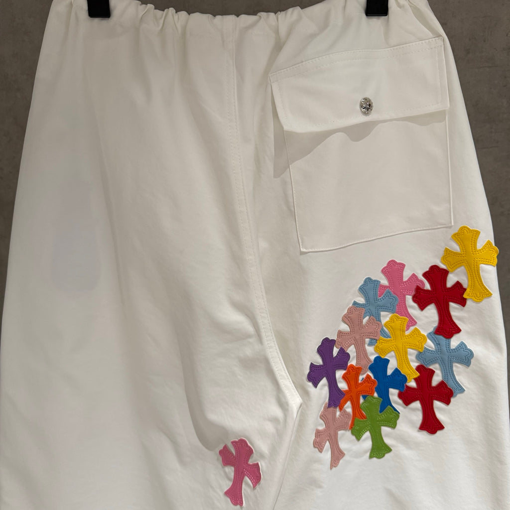 White cargo pants with side pocket flap and multicolor cross applique decoration
