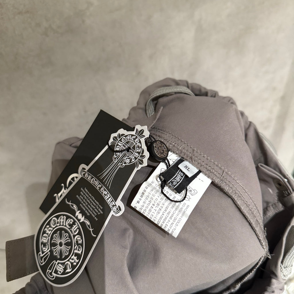 Taupe pants with drawstring waistband and attached clothing tag