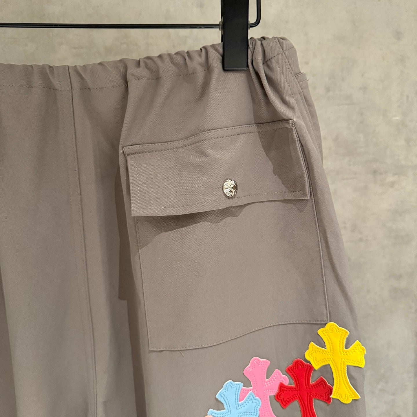 Taupe cargo pants with flap pocket and yellow cross applique