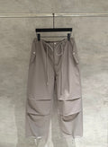 Taupe drawstring cargo pants with zip pockets and side flap details