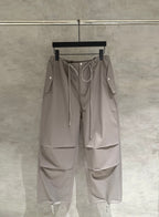 Taupe drawstring cargo pants with zip pockets and side flap details